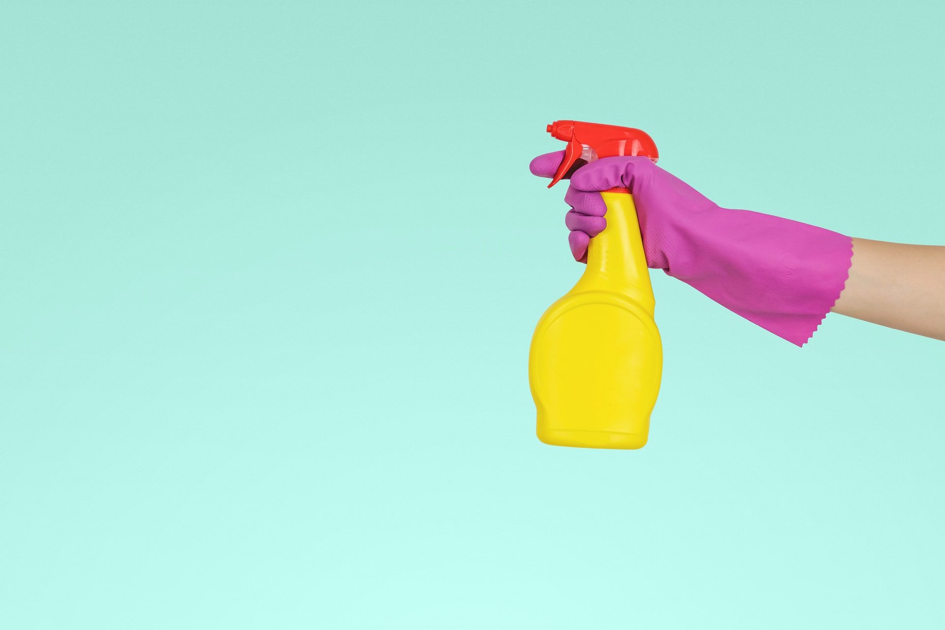 gloved hand with cleaning bottle 